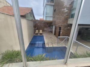 uma vista para uma piscina através de uma janela em Cozy Loft (Oceanview) em Niterói