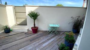 eine Terrasse mit einem Tisch und einer Topfpflanze in der Unterkunft Au 10 Bed & Breakfast in Luisant