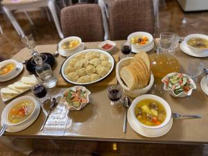 a table topped with bowls and plates of food at Hotel Diamond Kazbegi in Stepantsminda