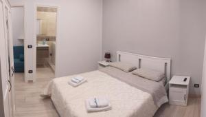 a white bedroom with a bed with two towels on it at Civico85 in Naples