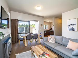 a living room with a couch and a table at Alpine Place - Spa and Mountain Views in Ohakune