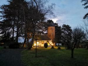 a house with a tower in the middle of a field at Le moulin de La Retardière in Orvault