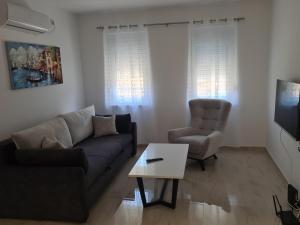 a living room with a couch and a chair and a table at Apartmani Marija in Vrdnik