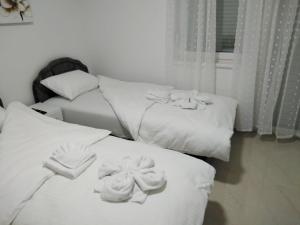 three beds with towels on top of them in a room at Apartmani Marija in Vrdnik