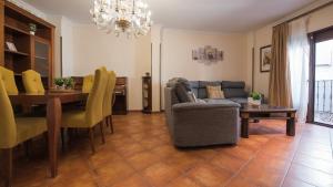 ein Wohnzimmer mit einem Sofa und einem Esstisch in der Unterkunft Caserío de Aljibillos 5 hab 8 camas 4 baños in Toledo