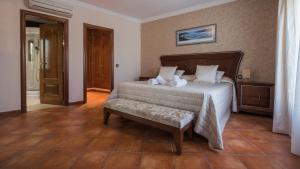 a bedroom with a bed with a bench in it at La Casa de Aljibillos by Toledo AP in Toledo