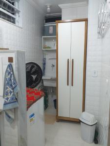 a kitchen with a refrigerator and a white cabinet at Apartamento Paraíso das Dunas em Cabo Frio in Cabo Frio
