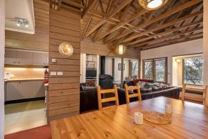 a kitchen and a living room with a wooden ceiling at Snowgums 13 in Dinner Plain