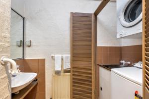 a small bathroom with a sink and a washing machine at Snowgums 13 in Dinner Plain +5 photos