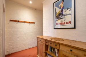 a room with a picture on the wall and a book shelf at Snowgums 13 in Dinner Plain