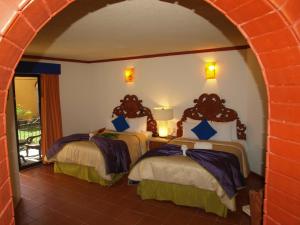 two beds in a room with an archway at Ecotel Quinta Regia in Valladolid +37 photos