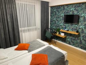 a hotel room with a bed and a flat screen tv at apartament LeśnaCedzyna in Kielce