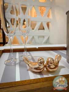 two wine glasses and a bird bowl on a table at Casa da Coruja in Rio de Janeiro