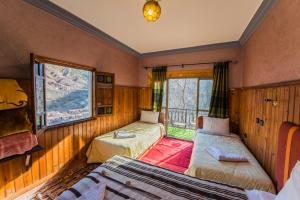 a bedroom with two beds and a window at Dar Adrar in Imlil