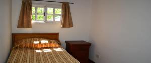 a small bedroom with a bed and a window at Cabañas del Norte in San Lorenzo