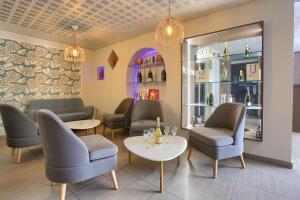 una sala de espera con sillas, mesas y botellas de vino en Sure Hotel by Best Western Reims Nord en Reims