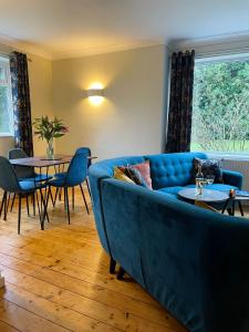 a living room with a blue couch and tables at Kist Accommodates - Stylish Headingley Apartment - Parking - 500 mps WIFI in Meanwood +27 photos
