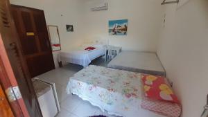 a small room with two beds and a table at Pousada Subindo as Dunas in Canoa Quebrada