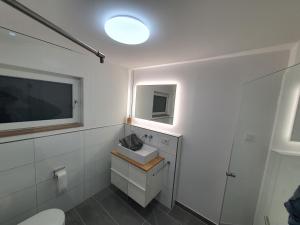a bathroom with a toilet and a tv on the wall at Fröbelnest in Filderstadt