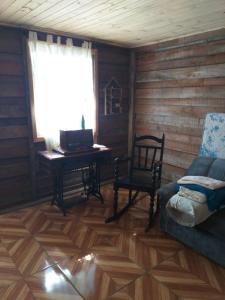 ein Wohnzimmer mit einem Sofa und einem Schreibtisch mit einem Laptop in der Unterkunft Chalé Sattwa Prudentópolis/WIFI/Pet/garagem in Prudentópolis