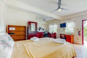 a bedroom with a large bed with two towels on it at Willow 2 at Island Cabanas Gold Standard Certified in Caye Caulker