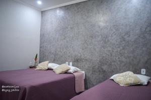 1 Schlafzimmer mit 2 Betten und lila Bettwäsche in der Unterkunft Oca Tocarijus Eco Resort in Piracuruca