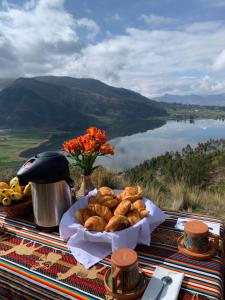 a plate of bread on a table with a view of a lake at Mountain View Lodge & Experience in Cusco +14 photos