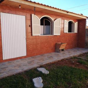 a brick house with white doors and a patio at Edícula Prudentópolis in Prudentópolis