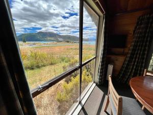 a room with a window with a table and a view at Church House Beside the Lake in Lake Tekapo
