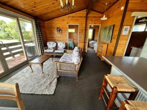 a living room with a couch and chairs in a cabin at Church House Beside the Lake in Lake Tekapo