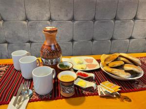 a table topped with plates of food and a vase at TATA Hotel Boutique in Cusco