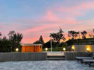 a sunset over a patio with a wooden building at Chez la Rose luxueuse cottage avec jacuzzi in Rouvres-la-Chétive