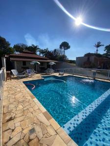a large swimming pool with blue water in a yard at RANCHO KWILL in Serra Negra