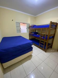 a bedroom with two bunk beds with blue sheets at RANCHO KWILL in Serra Negra +19 photos