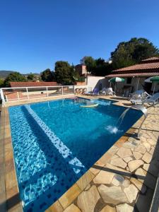 - une piscine d'eau bleue dans une maison dans l'établissement RANCHO KWILL, à Serra Negra