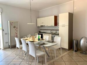 uma cozinha com uma mesa de jantar e electrodomésticos brancos em CasaRaphael em Pompeia