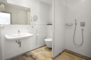 a white bathroom with a sink and a toilet at Hotel Filla Andre in Ernst