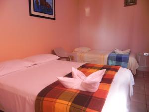 Habitación con 2 camas con mariposas blancas. en Hostal La Posada De Jose Carlos en Puerto Baquerizo Moreno