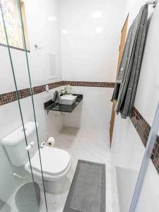 a small bathroom with a toilet and a sink at Pousada & Glamping Terra de Aquários in Aiuruoca