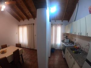 a kitchen with white cabinets and a table and a dining room at Departamento encantador en Maipú in Maipú