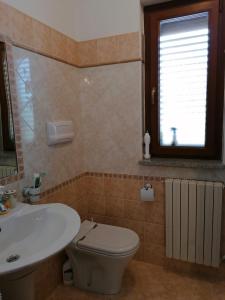 ein Bad mit einem WC, einem Waschbecken und einem Fenster in der Unterkunft La casa di Pina in Latronico