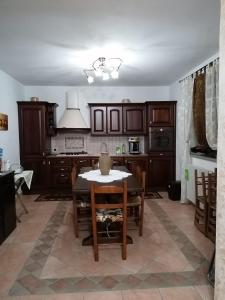 a kitchen with wooden cabinets and a table with chairs at La casa di Pina in Latronico