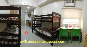 2 beliches num quarto com uma mesa e uma sala de jantar em Jhocson Residences em Manila