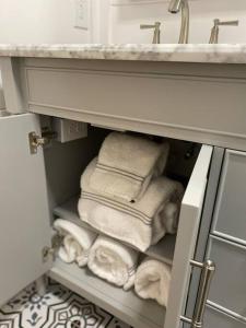 a bunch of towels in a cabinet under a sink at Cottage in Summerville