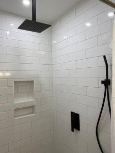 a white bathroom with a shower with a hose at Cottage in Summerville