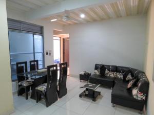 a living room with a couch and a table and chairs at Nirvana , Casa de Huéspedes in Melgar