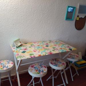 a table with four stools and a table with a bed at @casa__grace in Cartagena de Indias