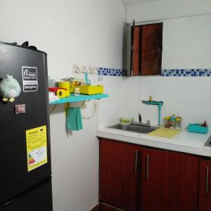 a kitchen with a black refrigerator and a sink at @casa__grace in Cartagena de Indias