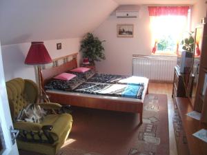 a bedroom with a bed and a chair and a television at Katalin vendégház in Sárospatak