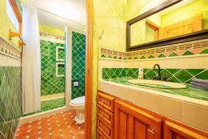 W łazience znajduje się umywalka, toaleta i lustro. w obiekcie OYO Whost San Miguel De Allende w mieście San Miguel de Allende